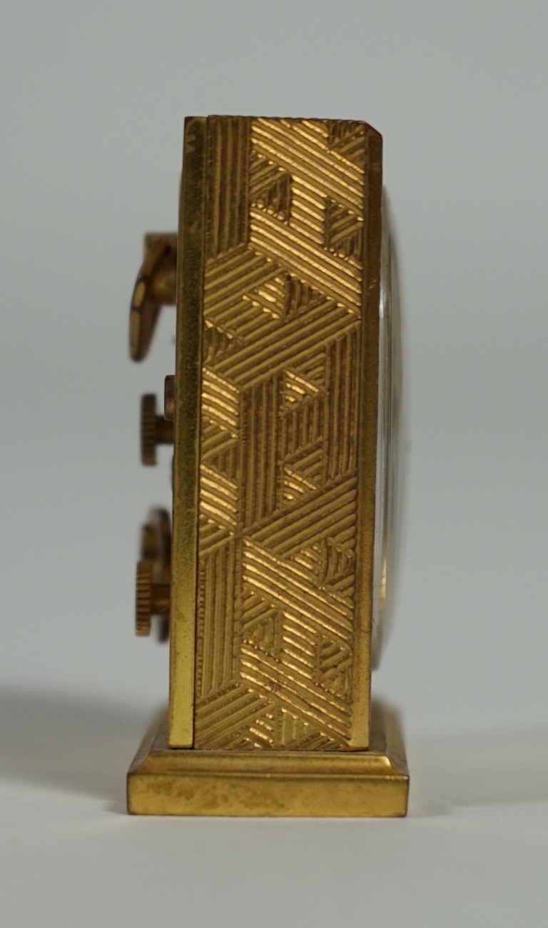 A Hermès travel alarm clock in gilded brass chiselled with H enchassés, height 5cm